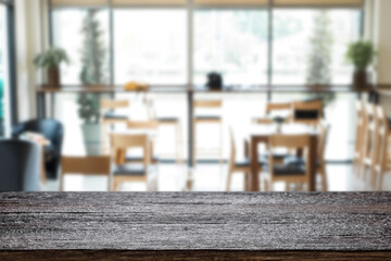 Empty wooden desk space platform over blurred restaurant or coffee shop background for product display montage.