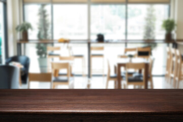 Empty wooden desk space platform over blurred restaurant or coffee shop background for product display montage.