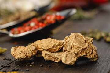 Dried ginger on dark wooden table close up