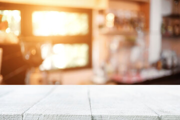 Empty wooden table space platform and blurred restaurant or coffee shop background for product display montage.