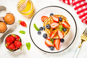 Pancakes with fresh berries and honey.