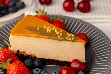 Piece of souffle cake with caramel top served with berries