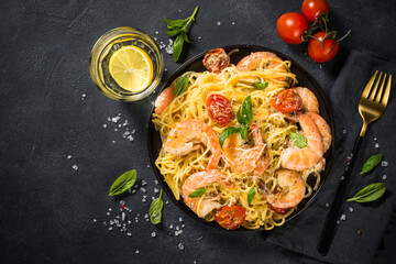 Pasta seafood with shrimp on black table.