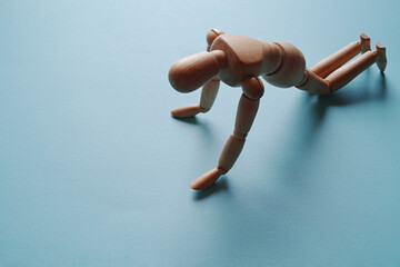 両膝と両手をついてうなだれるモデル人形【青背景】