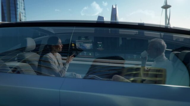 Zoom Out View of an Attractive Senior Female Reading the News on a Futuristic Augmented Reality Interface while Talking to Another Passenger. They are Riding in an Autonomous Self-Driving Car.