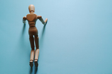 両膝と両手をついてうなだれるモデル人形【青背景・トップビュー】