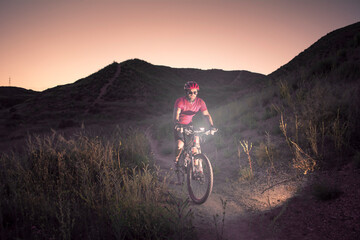 man riding a mountain bike at dusk