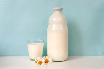 Glass and bottle of milk, on blue background. Natural food.