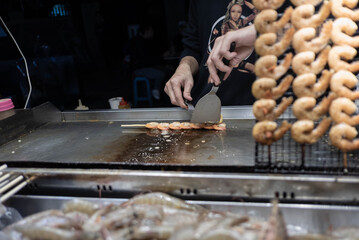 Chef cooking on grill at Taiwan night market
