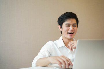 close up young asian man watching comedy variety show from website and laughing with ecstatic for social distance and new normal lifestyle concept