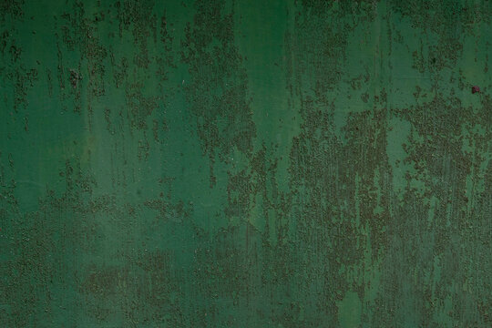 the surface of the old metal, pitted with rust, covered in old green paint