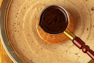 Turkish coffee in cezve on the sand