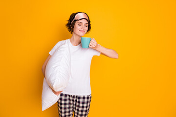 Portrait of her she nice attractive lovely pretty dreamy cheery brown-haired girl holding in hands pillow drinking warm milk isolated on bright vivid shine vibrant yellow color background