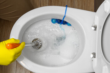 Man cleaning overflowing broken toilet. clogged toilet.