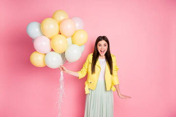 Portrait of her she nice-looking attractive pretty lovely cheerful cheery glad girl having fun holding in hands air balls isolated over bright vivid shine vibrant yellow color background