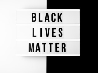 Light box with the text "black lives matter" against black and white background