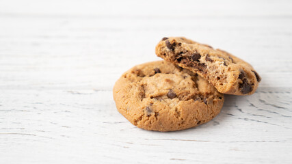 Bitten chocolate chip cookie. Two cookies with chocolate drops on white wooden table. place for message. Isolated