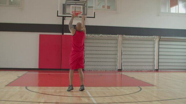 Rear View Of Athletic Handsome Concentrated African American Basketball Player In Uniform Practicing Free Throw Shot, Scoring A Goal During Sports Training On Indoor Basketball Court.