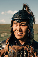 mongolian warrior with a sword standing on a hill in the sunset