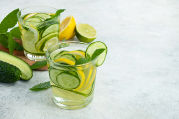 Infused water with cucumber, lime, lemon and mint in glass. Detox, healthy drink. Copy space, close...