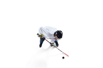 Unrecognizable male hockey player with the stick on ice court and white background. Sportsman wearing equipment and helmet practicing. Concept of sport, healthy lifestyle, motion, action. Top view.