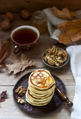Vegetarian breakfast of fritters with honey, nuts and tea. Autumn still life.