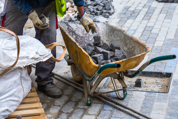 Construction work on pavement. Installation of concrete paver blocks on the sidewalk. The worker...