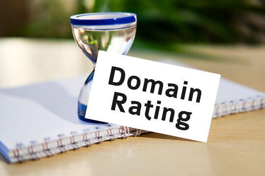 Domain rating business seo concept text on a white notebook and hourglass clock, green leaves of flowers