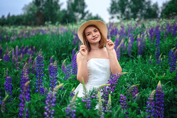 Beautiful girl in the middle of a field with lupins.
Lupine field and a beautiful girl. Beautiful woman in a lupine field