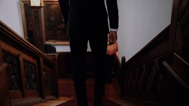 Man goes down the stairs in the castle, groom goes to his bride, silhouette of a man