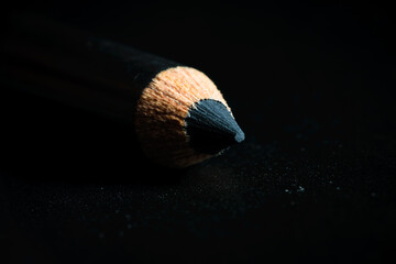 A macro shot of a black pencil tip. Kept in a dark background