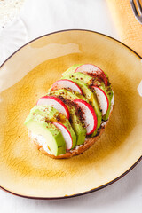 Toast with avocado and fresh radish.