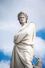 Fototapeta premium Statue of Dante Alighieri in Piazza di Santa Croce with cloudy sky background. Florence, Italy.