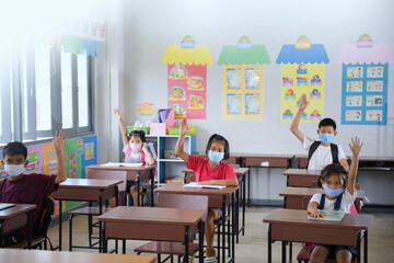 school kids with protection face mask against flu virus at lesson in classroom