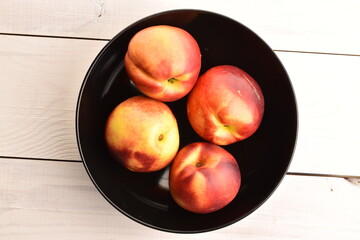 Ripe juicy organic nectarine, close-up, on a painted wooden table.