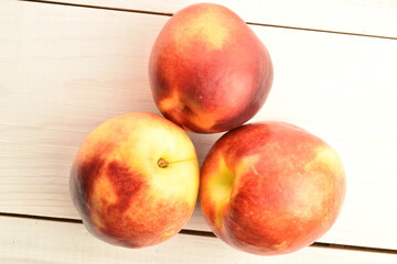Ripe juicy organic nectarine, close-up, on a painted wooden table.
