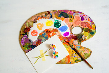 wooden art palette with paint and brushes on white.LGBT concept. lesbian gay , bisexual transsexual