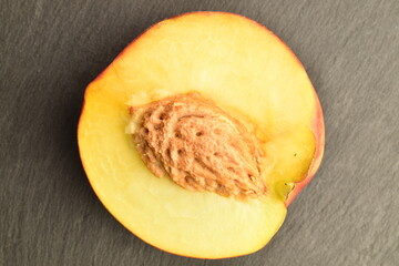 Ripe juicy organic nectarine, close-up, on a serving plate of slate.