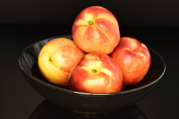 Ripe juicy organic nectarine, macro, on a black background.