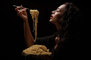 A beautiful girl eats with a fork spaghetti with red lips.