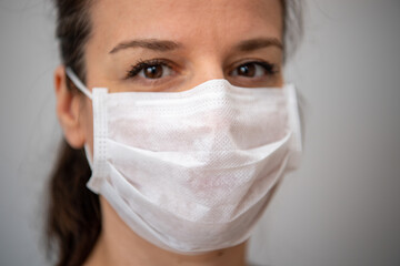 Head shot portrait attractive woman looking at camera wear medical white colour face mask