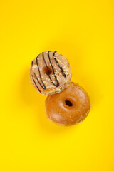 Assorted and colourful gourmet doughnuts on a vibrant yellow background