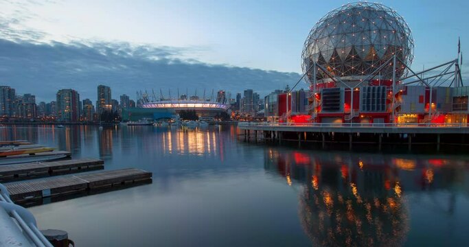 Panning time lapse shot of Science World and BC Place reflection in sea at harbor against sky - Vancouver, Canada