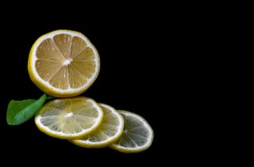 juicy lemon slices and leaf isolated on a black background space for text