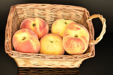 Ripe organic peach, close-up, in a wicker basket.