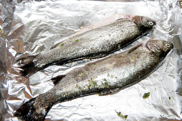 . whole trout fish without a head, with salt and rosemary. Top view.