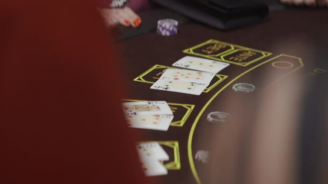 Croupier hand sorting and counting casino chips on roulette layout.