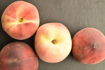 Ripe organic peach, close-up, on a serving plate of slate.