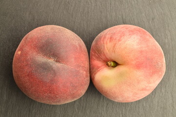 Ripe organic peach, close-up, on a serving plate of slate.