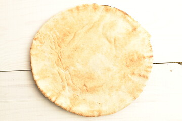 Fresh aromatic pita, close-up, on a wooden table.